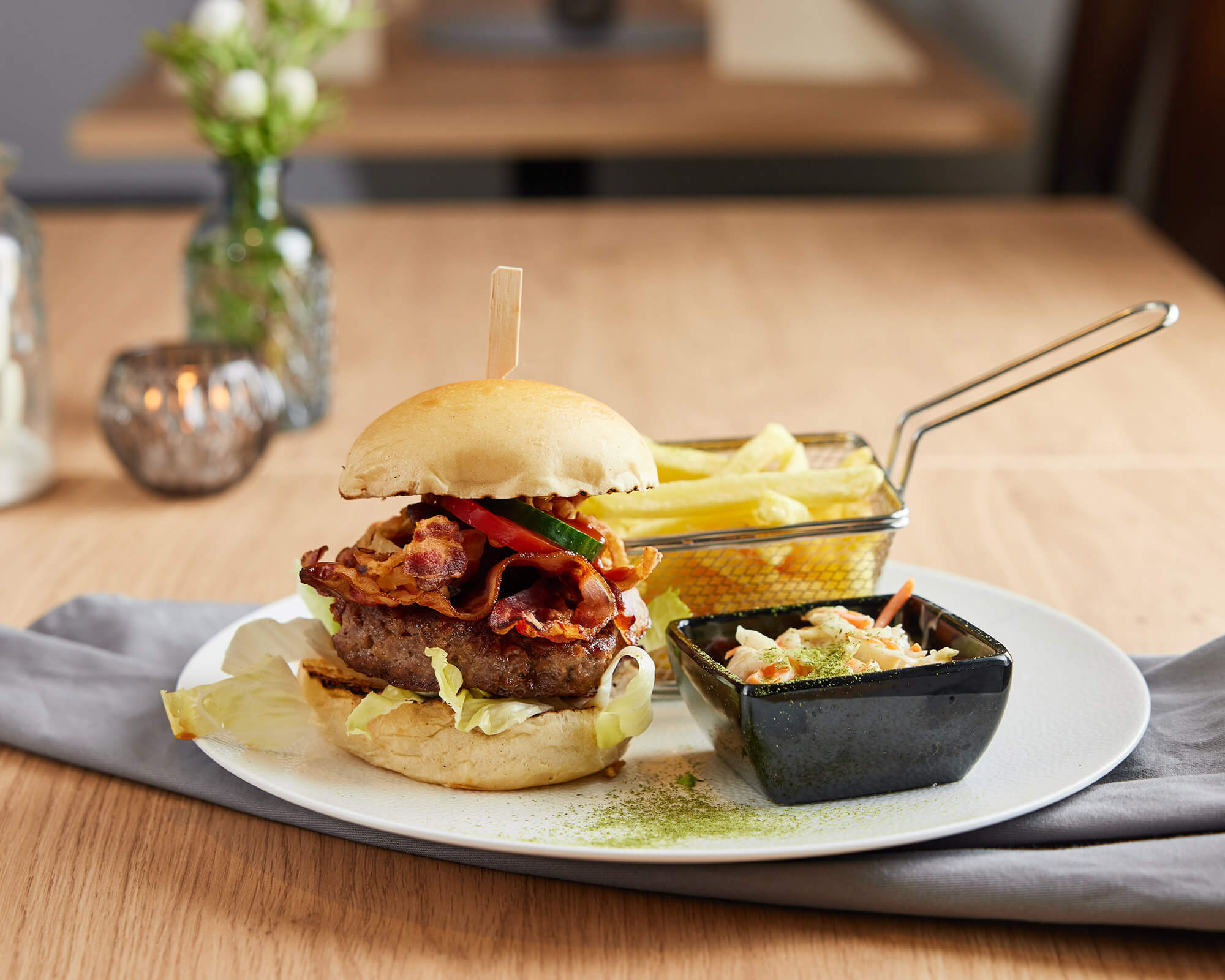 Burger mit Pommes und Colsaw auf Tisch